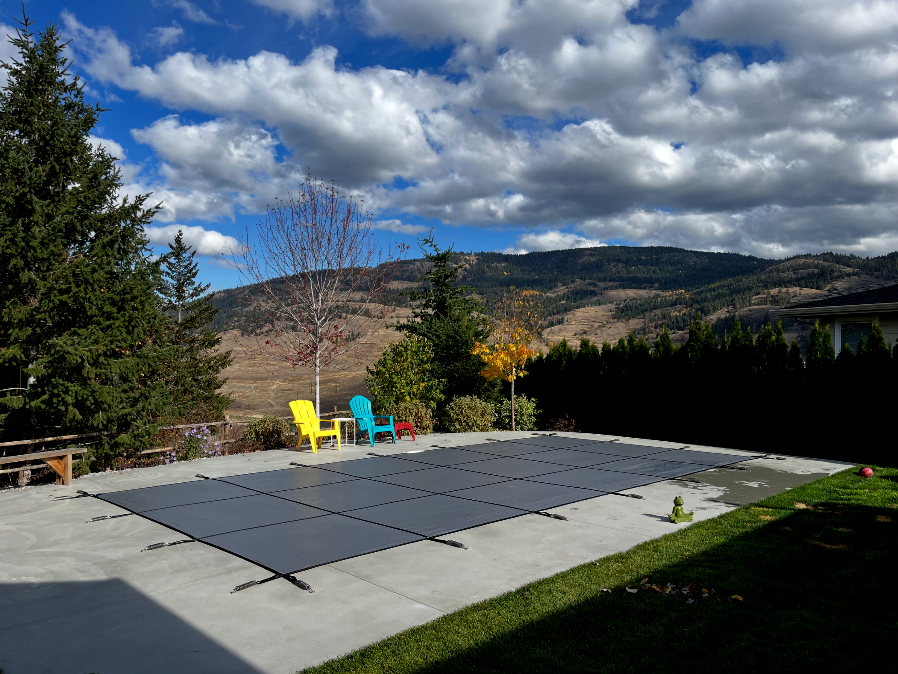 A fitted mesh safety cover over a backyard pool