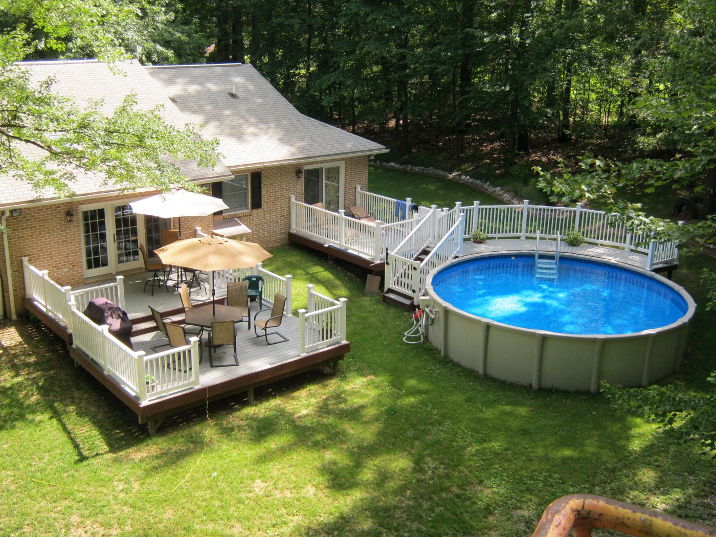 Above-ground pool set into a deck behind a house