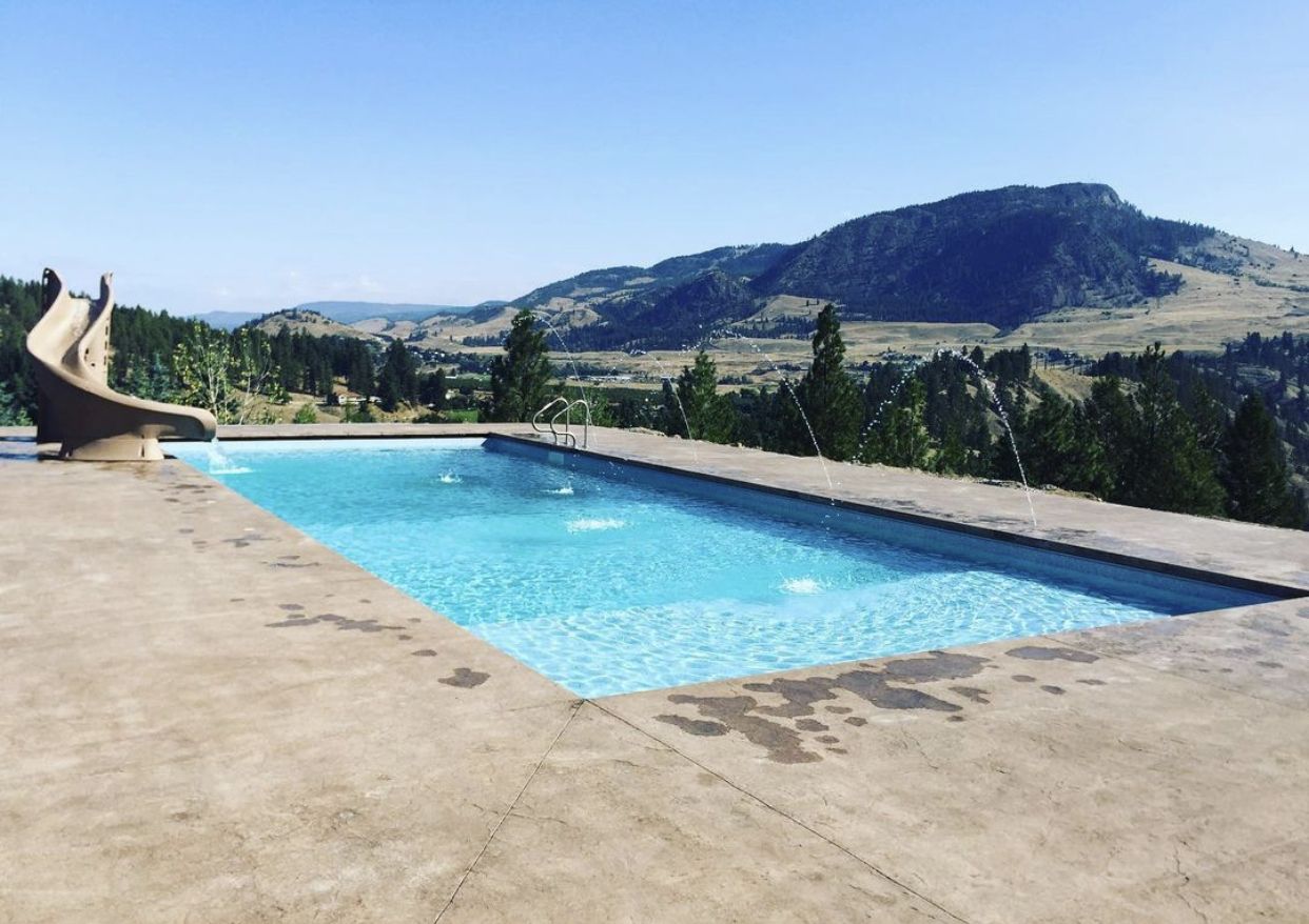 Pool with a slide below a mountain