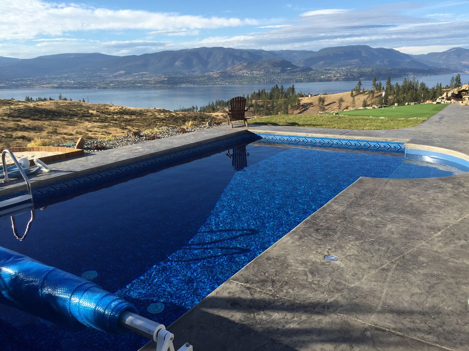 Long pool on a terrace with the lake and mountains beyond